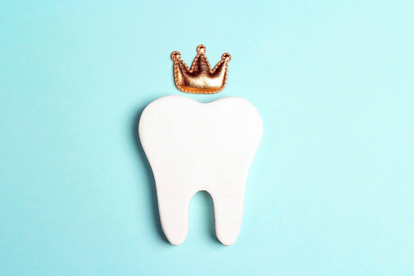 Tooth with golden crown on top.